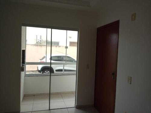 una puerta a una habitación con un coche en un estacionamiento en Apartamento na Praia dos Ingleses, en Florianópolis
