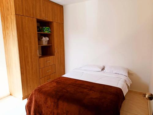 a bedroom with a bed and a wooden cabinet at Apartamentos Pitalito in Pitalito