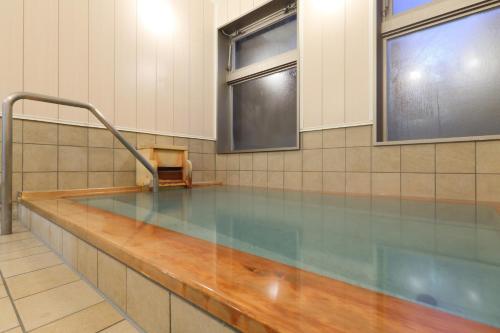 a swimming pool with a bench in a room at Kusatsu Onsen 326 Yamanoyu Hotel - Vacation STAY 10349v in Kusatsu