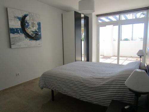 1 dormitorio con cama y ventana grande en 2155-Nice groundfloor with pool view, en Manilva