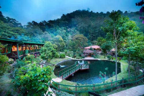 un tren que viaja por un puente sobre un río en Trogon Lodge, en San Gerardo de Dota