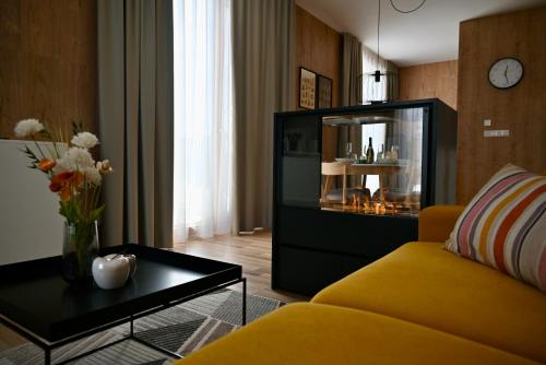 uma sala de estar com um sofá amarelo e uma mesa em KUBÍNSKA HOĽA - Apartmány HILLSIDE point em Dolný Kubín
