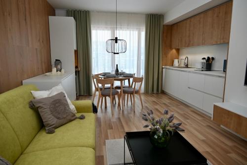 a living room with a green couch and a table at KUBÍNSKA HOĽA - Apartmány HILLSIDE point in Dolný Kubín