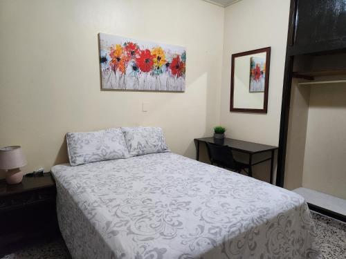 a bedroom with a bed and a painting on the wall at Casa Altamira in San Pedro Sula