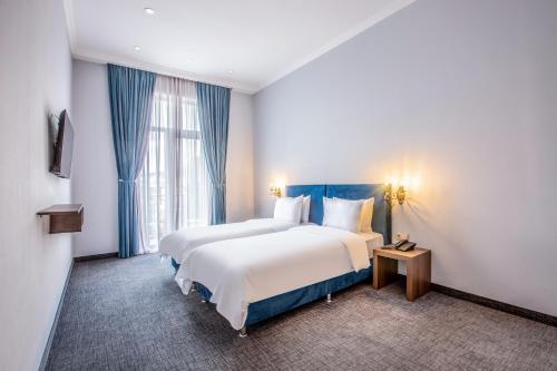 a hotel room with two beds and a window at Alma Boutique Hotel in Tbilisi City