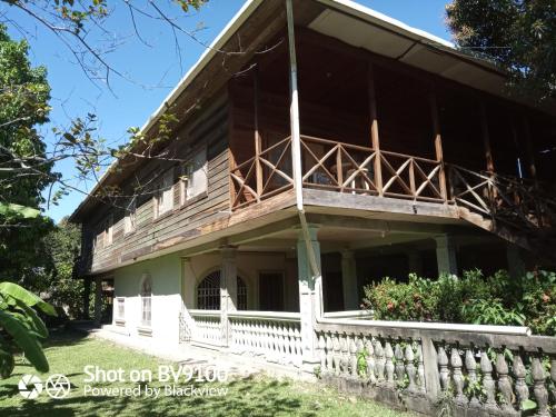 une maison avec un balcon sur le côté de celle-ci dans l'établissement Casa del Campo, à Tela