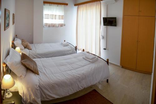 a bedroom with two beds and a window at CityCenter Apartment in Missolonghi