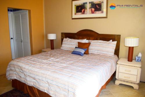 een slaapkamer met een bed met 2 nachtkastjes en 2 lampen bij Marina Pinacate B-319 in Puerto Peñasco