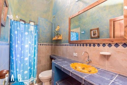 ein Badezimmer mit einem Waschbecken, einem WC und einem Spiegel in der Unterkunft Finca Quinta San Antonio, Girardota, Antioquia in Girardota