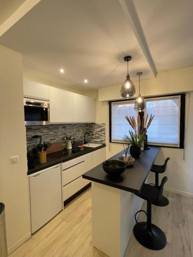 une cuisine avec des armoires blanches et un comptoir noir dans l'établissement Sublime Coeur Deauville, à Deauville