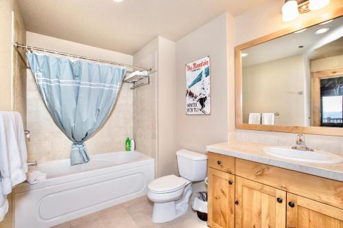 y baño con aseo blanco, lavabo y espejo. en Morning Eagle 411 en Whitefish