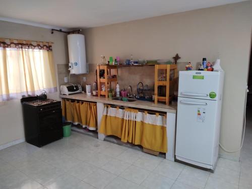 cocina con nevera blanca y fregadero en Casas Arnau en Termas de Río Hondo