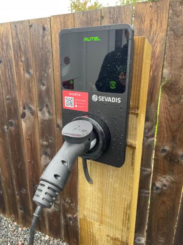 a pay phone is attached to a wooden fence at Courtyard Bothy in Grantown on Spey