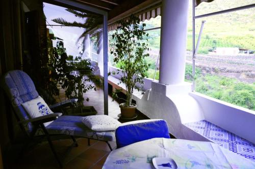 Habitación con 2 sillas, mesa y ventana en CASA LA ROSA, en Leni