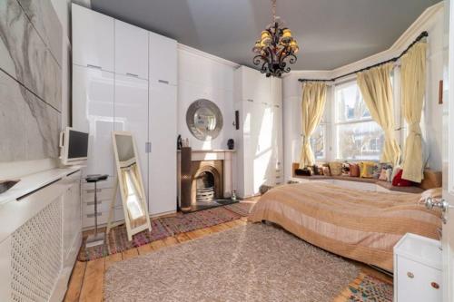Elgin Terrace في لندن: غرفة نوم كبيرة مع سرير ومدفأة