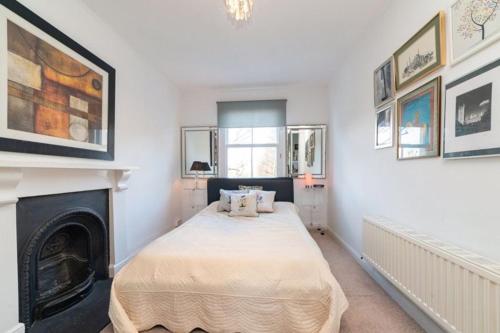 Elgin Terrace في لندن: غرفة نوم بسرير ومدفأة