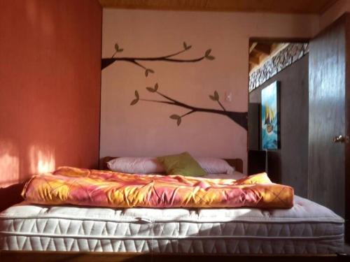 a bedroom with a bed with a branch on the wall at Arriendo Casa Pichidangui in Los Vilos