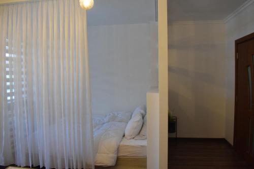 ein Schlafzimmer mit einem Bett und einem weißen Vorhang in der Unterkunft Green Life Bansko Apartments in Bansko