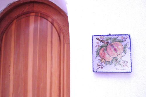 a painting of pomegranates on a wall next to a door at CASA LA ROSA in Leni