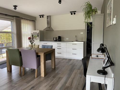 a kitchen with a wooden table and a dining room at Appartement B&B De Koning in Afferden
