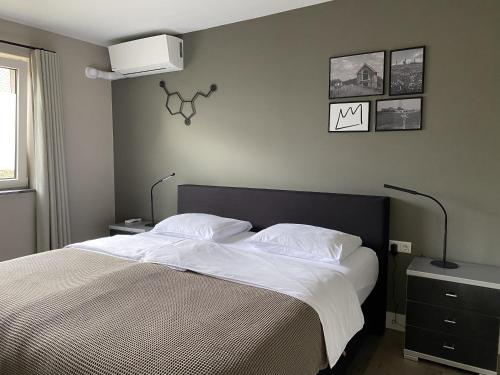 1 dormitorio con 1 cama grande con sábanas blancas en Appartement B&B De Koning, en Afferden