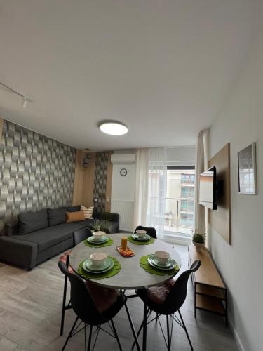 ein Wohnzimmer mit einem Tisch, Stühlen und einem Sofa in der Unterkunft Apartament Sportowa in Suwałki