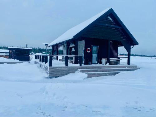 a small building in the snow with a red door at Spithami Seaside Wooden Chalet in Spithami