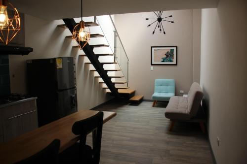 a living room with a spiral staircase and a blue chair at Hotel Plaza El Santuario in Santuario