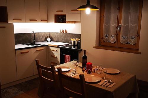 a kitchen with a table with glasses and a bottle of wine at Happy Bolbeno House CIPAT: 022239-AT-814829 in Saone