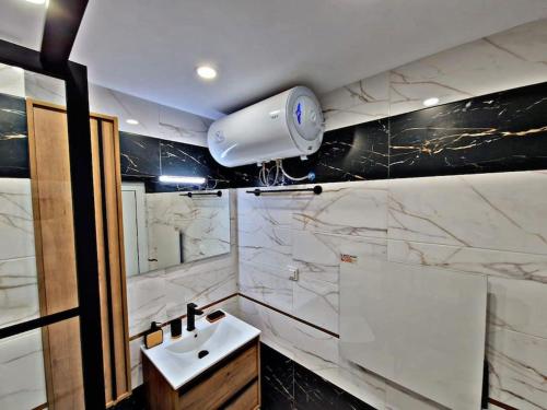 a bathroom with a sink and a light on the wall at 1 bedroom luxury apartment Milena -free parking in Pamporovo