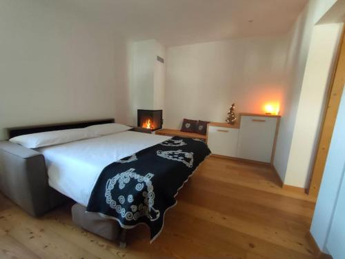 a bedroom with a large bed with a black and white blanket at Happy Bolbeno House CIPAT: 022239-AT-814829 in Saone