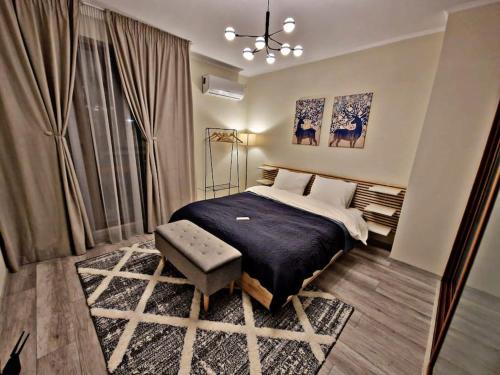 a bedroom with a bed and a chair and a window at 1 bedroom luxury apartment Milena -free parking in Pamporovo