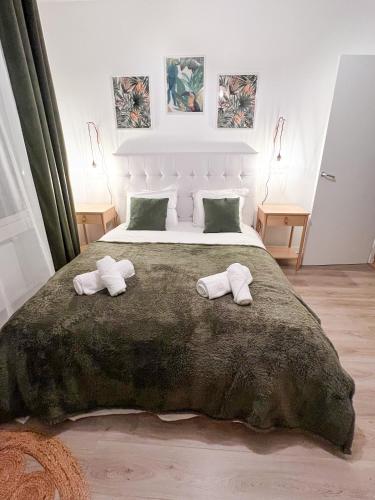 une chambre avec un grand lit avec deux serviettes dessus dans l'établissement Le jardin secret d'Amiens Hypercentre cathédrale, Parking, à Amiens