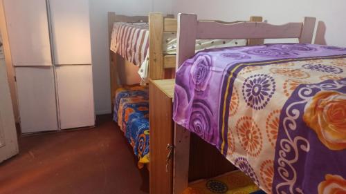 a bedroom with two bunk beds and a refrigerator at CasaHostel in Buenos Aires
