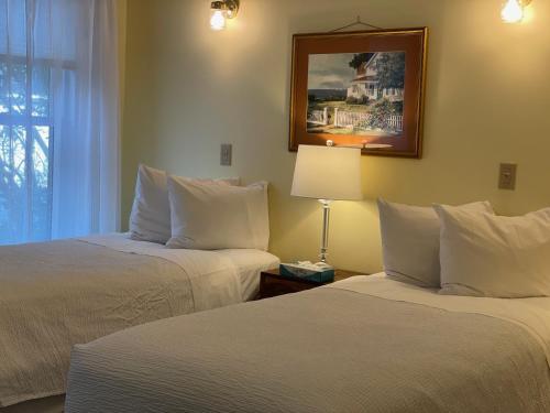a hotel room with two beds and a picture on the wall at Central House Inn in Bar Harbor