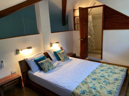 a bedroom with a large bed with blue pillows at Stunning Loft 2 Floor Unit with Balcony in Contadora