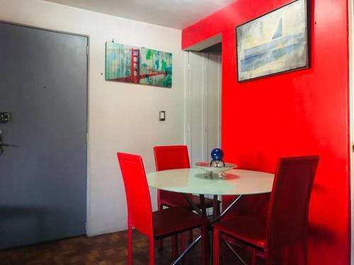 comedor con paredes rojas, mesa y sillas en Lovely Depa. Forosol Palacio Airport 10 Min, en Ciudad de México