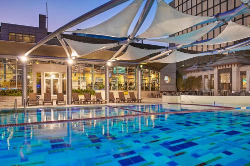 uma grande piscina com uma marquise num edifício em Crowne Plaza Kuwait Al Thuraya City, an IHG Hotel em Kuwait