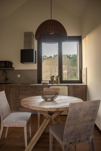 a kitchen with a table and chairs and a window at Balarés Hotel da Natureza in Ponteceso