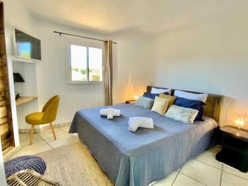 a bedroom with a blue bed with a chair and a window at Concadoro in Porto-Vecchio