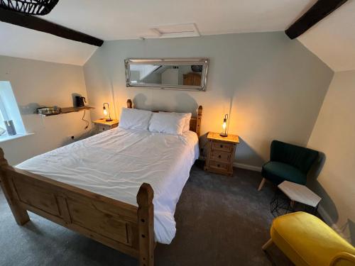 een slaapkamer met een groot bed en een groene stoel bij La Fattoria in Durham