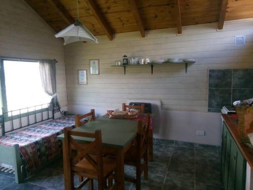 una sala da pranzo con tavolo, sedie e letto di La casa de la abuela Cabaña a El Bolsón