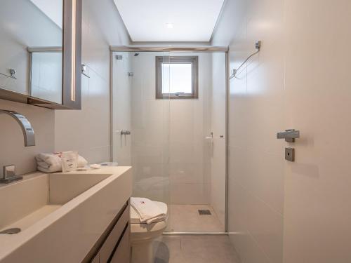 a bathroom with a shower and a toilet and a sink at Allure 102 - Apto em Gramado Av das Hortênsias in Gramado