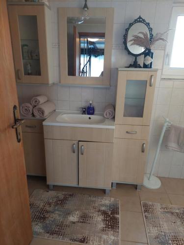 W łazience znajduje się umywalka i lustro. w obiekcie Hilltop House. w mieście Erdut