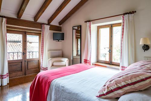 a bedroom with a bed with a red blanket at Excepcional Casa El Olivo in Ojedo