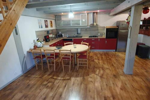 a kitchen with a table and chairs in a room at Grand appartement neuf avec parking gratuit. in Malbuisson