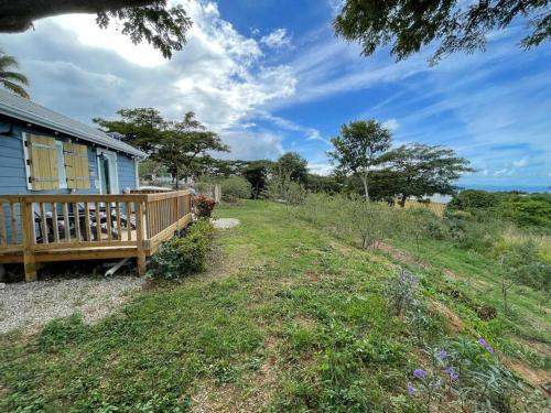 una casa con portico in legno e cortile di Vista Mar y Tierra - Tiny House on an acre with ocean view 