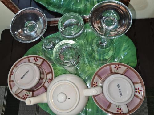a table with cups and glasses on a table at Budget Friendly Transient in Cainta hosted by Aliyah in Cainta