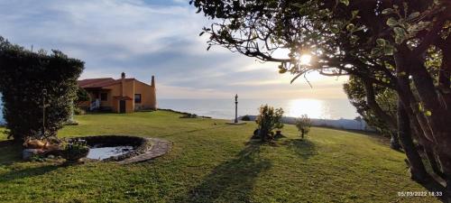 a house on the shore of the ocean with the sun setting at A Guaira: fantástica alojamiento con finca sobre el mar in Oia