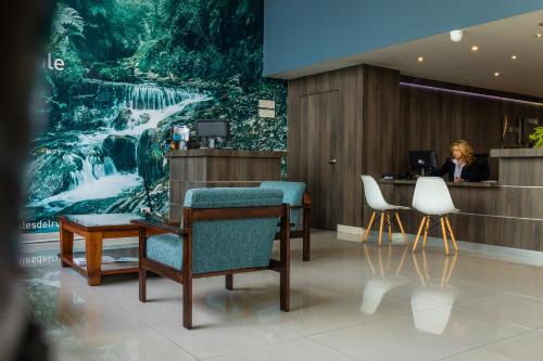 a woman sitting at a reception desk in a lobby at Hotel Carretero in Manizales